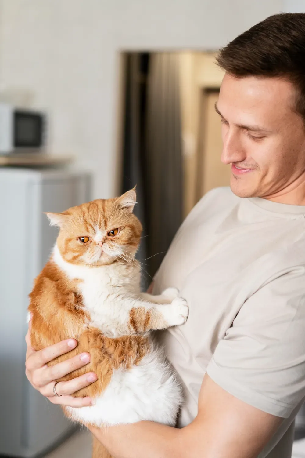 A man holding a cat in his hands.